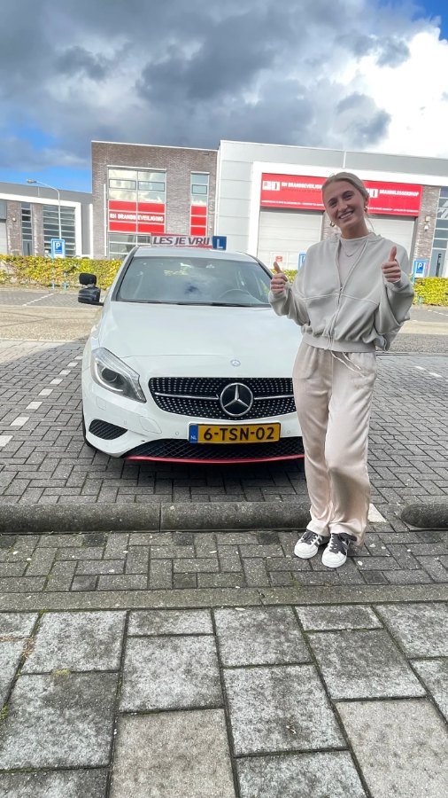 Geslaagde leerling bij de lesauto van Rijschool Les je Vrij in het Westland