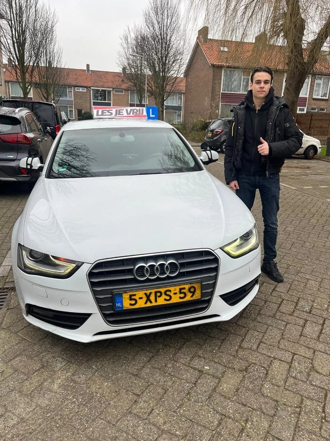Geslaagde leerling van Rijschool Les je Vrij met het lesbord