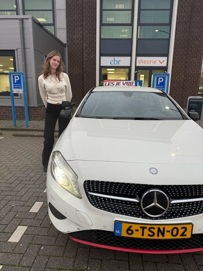 Geslaagde leerling bij de lesauto van Rijschool Les je Vrij in het Westland