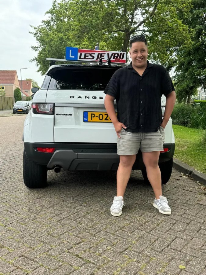 Geslaagde leerling van Rijschool Les je Vrij met het lesbord