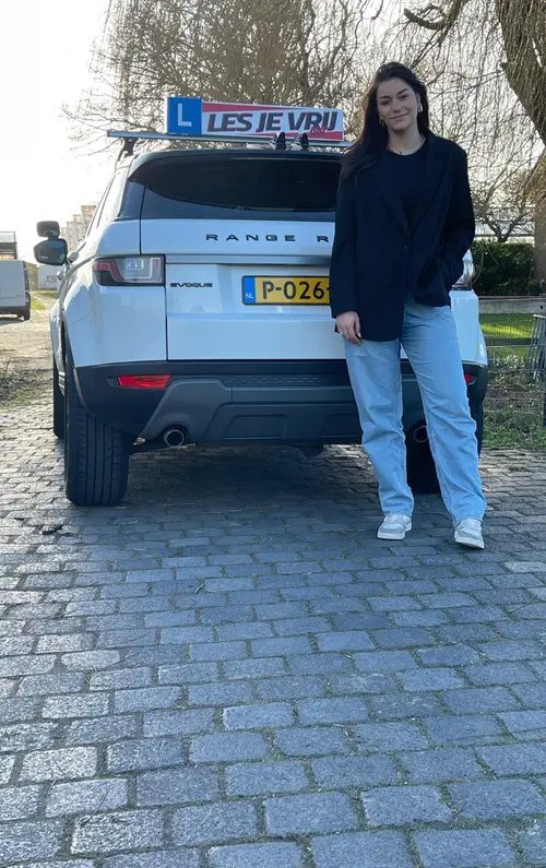 Geslaagde leerling van Rijschool Les je Vrij met het lesbord