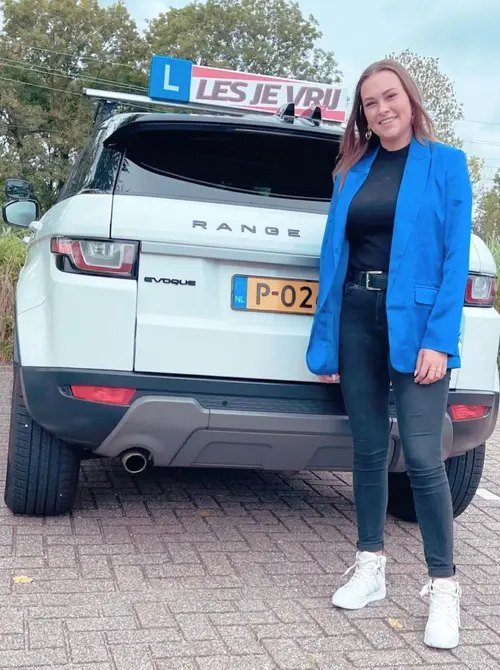 Geslaagde leerling naast de lesauto in het Westland