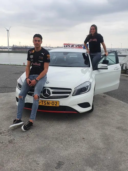 Geslaagde leerling van Rijschool Les je Vrij met het lesbord