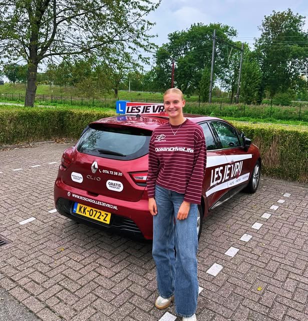 Geslaagde leerling bij de lesauto van Rijschool Les je Vrij in het Westland