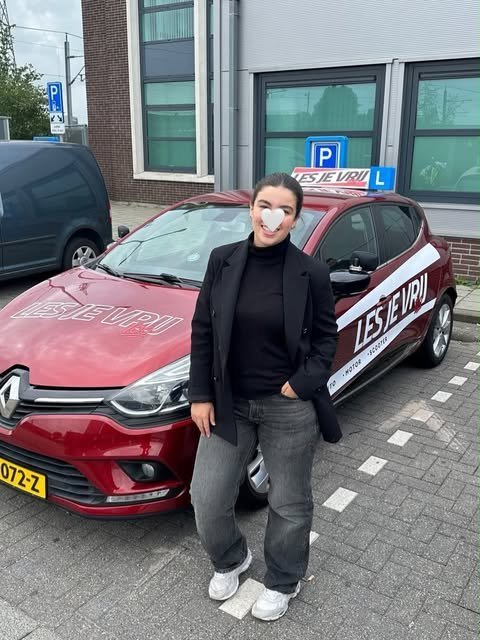 Geslaagde leerling van Rijschool Les je Vrij met het lesbord